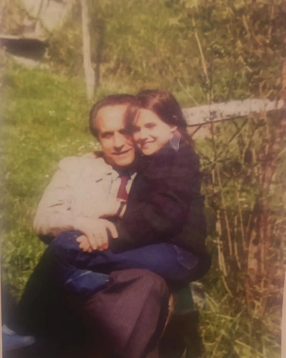 Chiara bambina in braccio al papà, nel giardino della villa del pittore Sabatelli